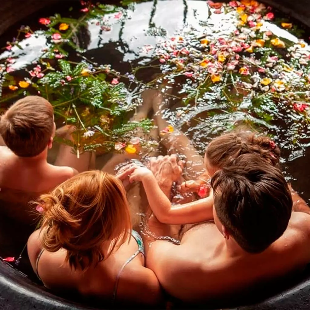 family is steaming in off the grid hot tub with herbs
