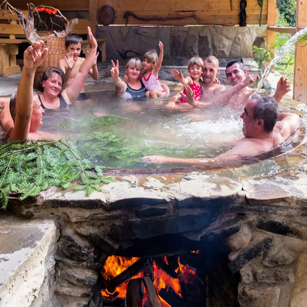 family rest with children in the metal hot tubs