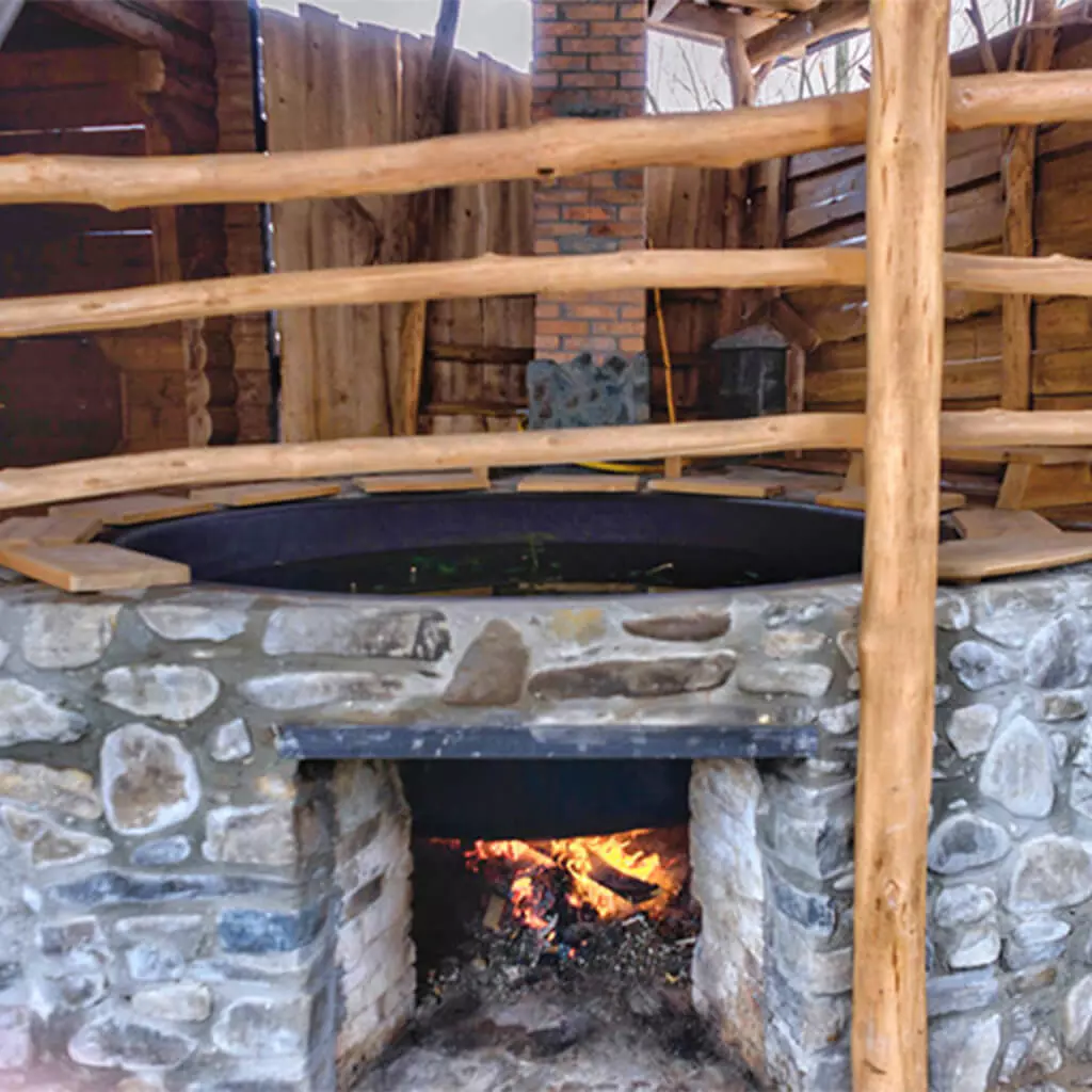 outdoor hot iron tub at backyard with burning fire