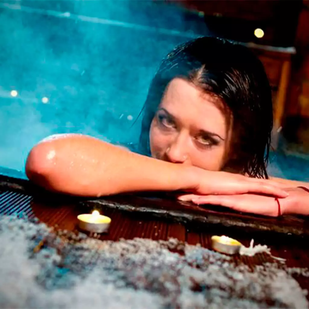 woman is looking at you from outdoor hot tube